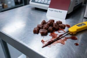 Failed batch of gummy candies melting on a lab table due to heat instability, illustrating the challenges of Formulating with Natural Food Colors.
